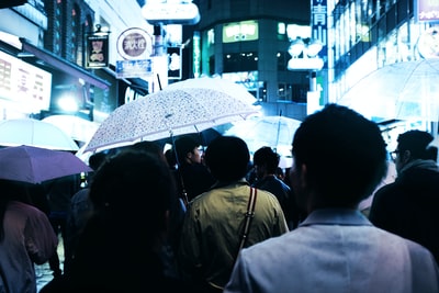 雨伞的人晚上走在路中间的建筑物
